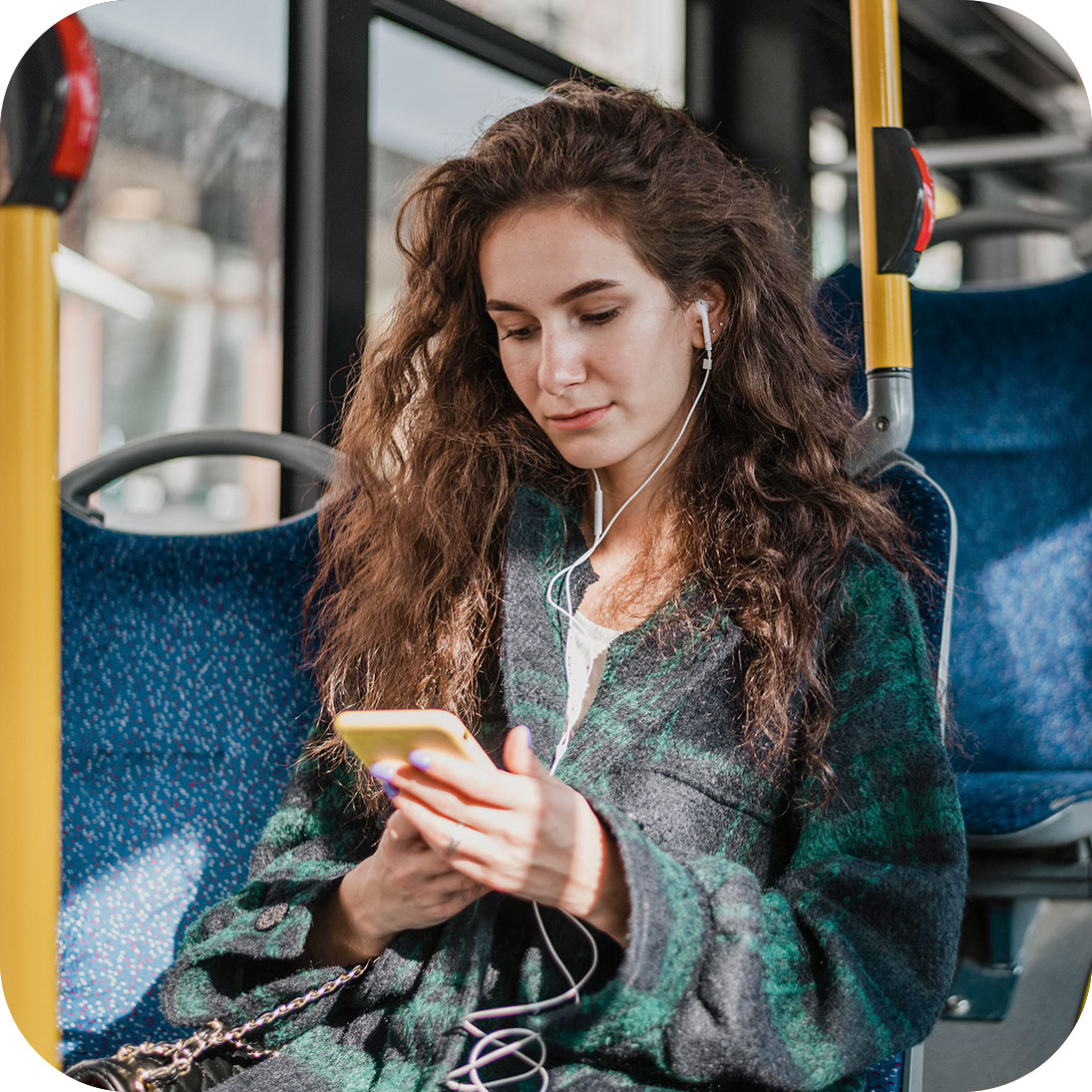 Mulher jovem usando celular sentada dentro de ônibus